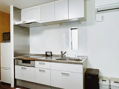 a white kitchen with a sink and a refrigerator at Tokyo Private villa/near station/Ginza/Asakusa/Sky Tree/Louis House in Tokyo