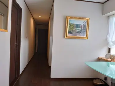 a hallway with a painting on the wall and a table at \u773a\u3081\u306e\u3044\u3044\u4e00\u8ed2\u5bb6 in Tokyo