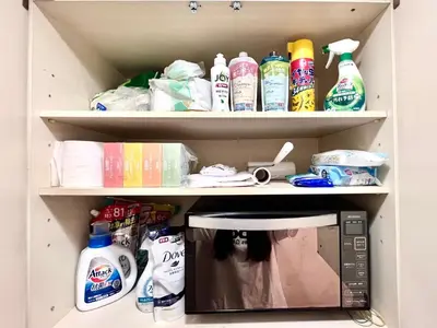 a kitchen pantry with a microwave and cleaning products at \u5de3\u9d28 \u6700\u59274\u4eba in Tokyo