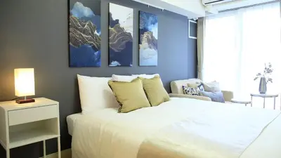 a bedroom with a large white bed and a chair at shinjuku1 in Tokyo