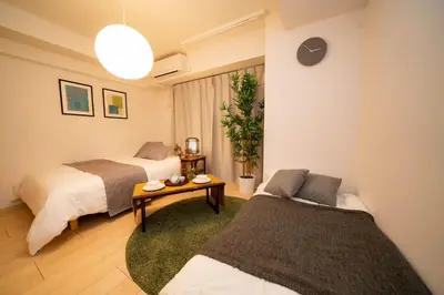 a bedroom with two beds and a table at shinjuku1 in Tokyo