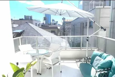 a balcony with a table and a white umbrella at \u6e0b\u8c37\u307e\u30672\u99c510\u5206!!\u4e00\u68df\u307e\u308b\u3054\u3068\u8cb8\u3057\u5207\u308a!\u99c5\u5f92\u6b693\u5206\u30da\u30c3\u30c8\u6b53\u8fce\u304a\u5b50\u69d8\u6b53\u8fce\u99d0\u8eca\u5834\u7121\u65996\u4eba\u307e\u3067 in Tokyo
