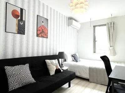 a living room with a couch and a bed at COMMA HOUSE Nishi-ikebukuro 2223 in Tokyo