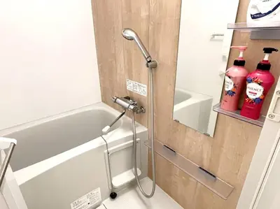 a bathroom with a shower with two bottles of cleaner at COMMA HOUSE Nishi-ikebukuro 2223 in Tokyo