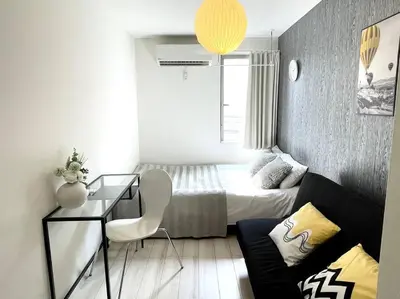 a small bedroom with a bed and a desk in it at COMMA HOUSE Nishi-ikebukuro 2223 in Tokyo