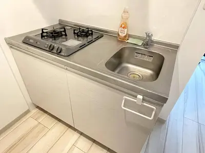 a kitchen with a stove and a sink at COMMA HOUSE Nishi-ikebukuro 2223 in Tokyo