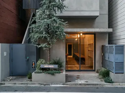 a front door of a building with a tree at Hotel Plus Hostel TOKYO ASAKUSA 1 in Tokyo