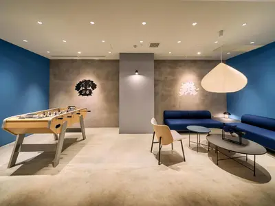 a living room with a table and a blue couch at Hotel Plus Hostel TOKYO ASAKUSA 1 in Tokyo