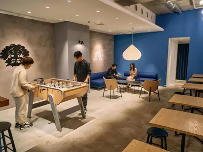 a group of people playing chess in a room at Hotel Plus Hostel TOKYO ASAKUSA 1 in Tokyo