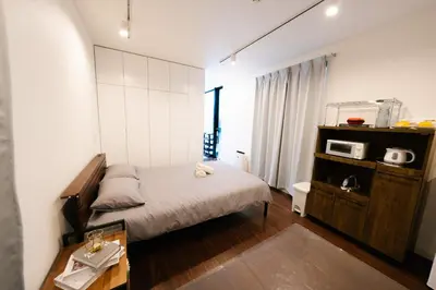 a small bedroom with a bed and a microwave at FL Residence Shinjuku Kawadacho in Tokyo