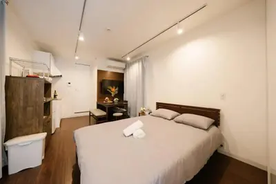 a bedroom with a large white bed and a desk at FL Residence Shinjuku Kawadacho in Tokyo