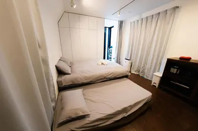 two beds in a small room with a window at FL Residence Shinjuku Kawadacho in Tokyo