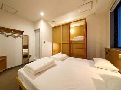 a bedroom with a large white bed in a room at Hotel Plus Hostel TOKYO ASAKUSA 2 in Tokyo