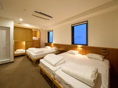 a room with three beds and two windows at Hotel Plus Hostel TOKYO ASAKUSA 2 in Tokyo