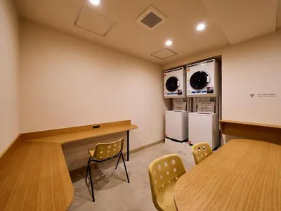 a room with a table and chairs and a kitchen at Hotel Plus Hostel TOKYO ASAKUSA 2 in Tokyo