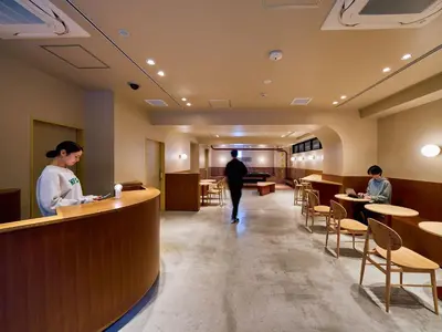 a man and a woman standing at a counter in a restaurant at Hotel Plus Hostel TOKYO ASAKUSA 2 in Tokyo