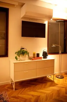 a room with a dresser with a tv on the wall at #5 3stops to Shinjuku station stylish spacious studio apartment in Tokyo