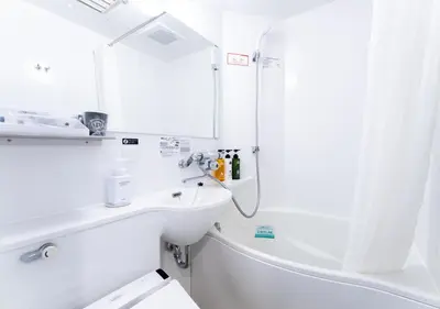 a white bathroom with a sink and a shower at APA Hotel Shinjuku Gyoemmae in Tokyo