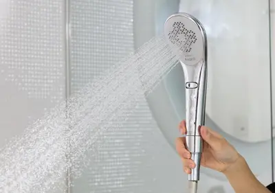 a person is holding a shower brush in front of a window at APA Hotel Shinjuku Gyoemmae in Tokyo