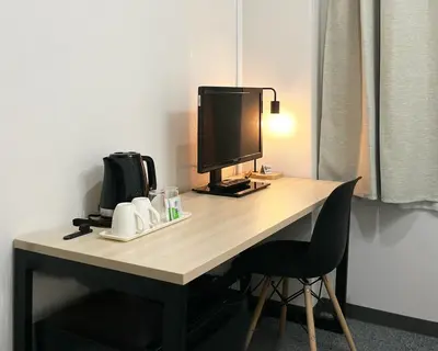 a desk with a computer monitor and a chair at Hotel Royal Oak Gotanda in Tokyo