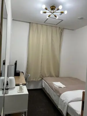 a bedroom with a bed and a ceiling fan at Hotel Royal Oak Gotanda in Tokyo