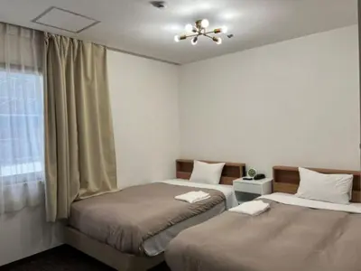 a bedroom with two beds and a window at Hotel Royal Oak Gotanda in Tokyo