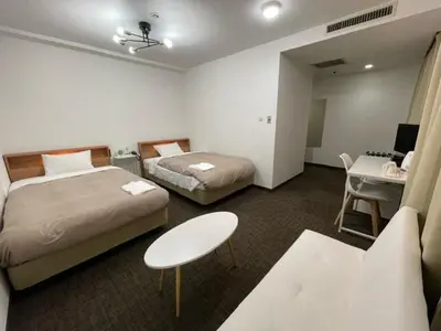 a hotel room with two beds and a desk at Hotel Royal Oak Gotanda in Tokyo