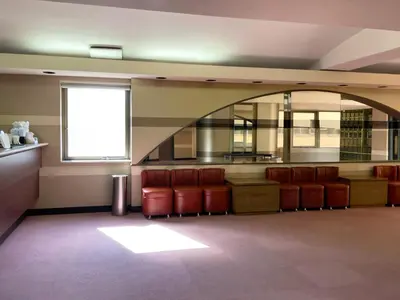 a waiting room with red chairs and a window at Hotel Royal Oak Gotanda in Tokyo