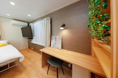 a bedroom with a desk and a bed and a tv at Convertel Daita by Tranova in Tokyo