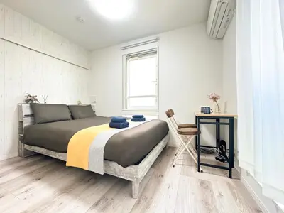 a bedroom with a large bed and a table at nestay apartment tokyo waseda in Tokyo