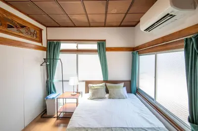a bedroom with a bed with green curtains and a window at 2023年8月オープン/入谷駅から徒歩10分/収容人数6/浅草寺徒歩10分/上野駅タクシー7分2km in Tokyo