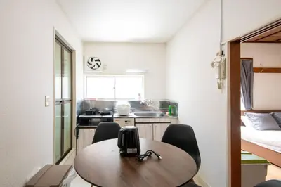 a small kitchen with a wooden table and chairs at 2023年8月オープン/入谷駅から徒歩10分/収容人数6/浅草寺徒歩10分/上野駅タクシー7分2km in Tokyo