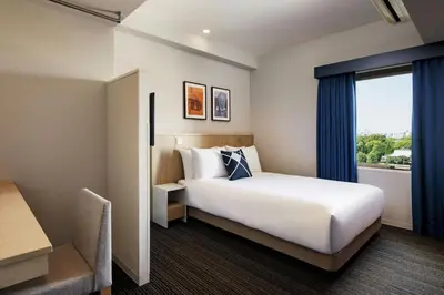 a hotel room with a bed and a window at Four Points Flex by Sheraton Tokyo Ueno in Tokyo