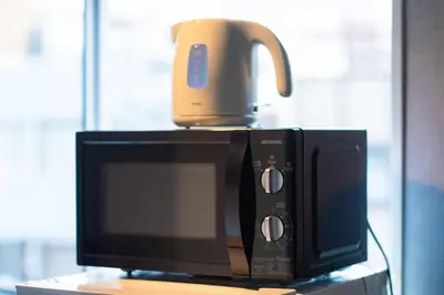 a coffee pot sitting on top of a microwave at Yoyogi Apartment 1-401 by Tranova in Tokyo