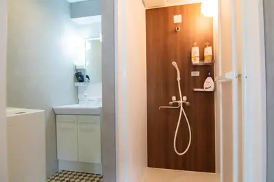a bathroom with a shower with a wooden door at Yoyogi Apartment 1-401 by Tranova in Tokyo