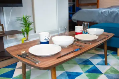 a wooden table with plates and bowls on it at Yoyogi Apartment 1-401 by Tranova in Tokyo