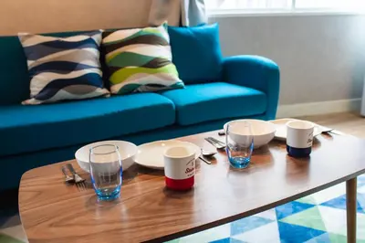 a wooden coffee table with plates and glasses on it at Yoyogi Apartment 1-401 by Tranova in Tokyo