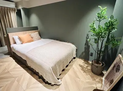 a bedroom with a bed and two potted plants at HOTEL KANMA UENO in Tokyo