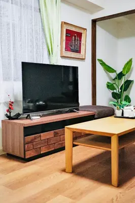 a living room with a large flat screen tv at \u6c60\u888b\u65b0\u5bbf\u6da9\u8c37\u4e09\u5730\u57fc\u4eac\u7ebf9\u5206\u81f316\u5206\u76f4\u8fbe \u53ef\u4f4f2\u4eba\u81f310\u4eba \u661f\u306e\u5712 in Tokyo