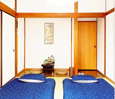 two blue beds in a room with a cross on the wall at TOKYO/Shinjuku & Shibuya 10mins/5mins walk to subway stiaon/Kichijoji 15mins/Shimokitazawa 5mins/Louis House in Tokyo