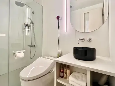 a white bathroom with a toilet and a shower at \u4e1c\u4eac\u4e0a\u91ce\u8d85\u7ea7\u4e2d\u5fc3 \u8bbe\u8ba1\u5e08\u623f\u95f4Yaob \u4e0a\u91ce\u516c\u56ed3\u5206\u949f \u8f66\u7ad91\u5206\u949f \u8d85\u7ea7\u7e41\u534e \u514d\u8d39wifi \u6234\u68ee\u5439\u98ce in Tokyo