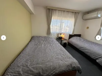 a bedroom with two beds and a window at Hotel Yuni Star-Club in Tokyo