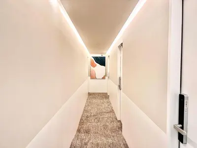 a corridor of a hallway with white walls at \u4e1c\u4eac\u4e0a\u91ce\u8d85\u7ea7\u4e2d\u5fc3 \u8bbe\u8ba1\u5e08\u623f\u95f4Yaoa \u4e0a\u91ce\u516c\u56ed3\u5206\u949f \u8f66\u7ad91\u5206\u949f \u8d85\u7ea7\u7e41\u534e \u514d\u8d39wifi \u6234\u68ee\u5439\u98ce in Tokyo