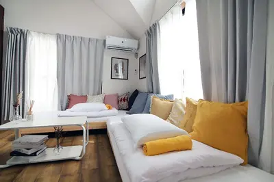 a living room with a couch with pillows on it at SUNRISE in Tokyo