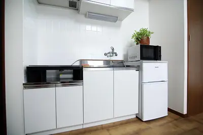 a white kitchen with a sink and a microwave at SUNRISE in Tokyo