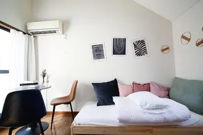 a bedroom with a bed and a desk and a chair at SUNRISE in Tokyo