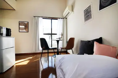 a bedroom with a bed and a table and chairs at SUNRISE in Tokyo