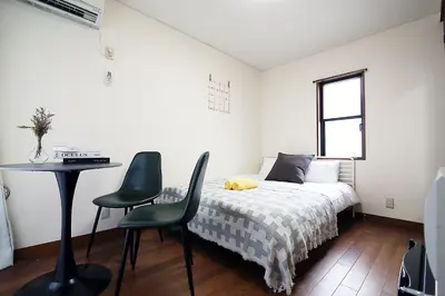 a bedroom with a bed and a table and chairs at SUNRISE in Tokyo