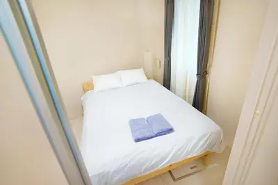 a small white bed in a room with a window at FL Residence Shinjuku II in Tokyo