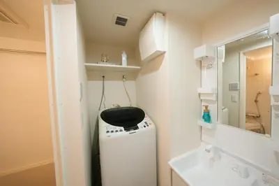 a small bathroom with a washer and dryer in it at FL Residence Shinjuku II in Tokyo